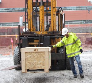 Fork lift moving crate into Sweeney