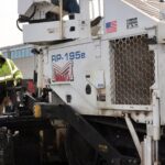 Photo of asphalt paving equipment and Prof. Eric Cochran