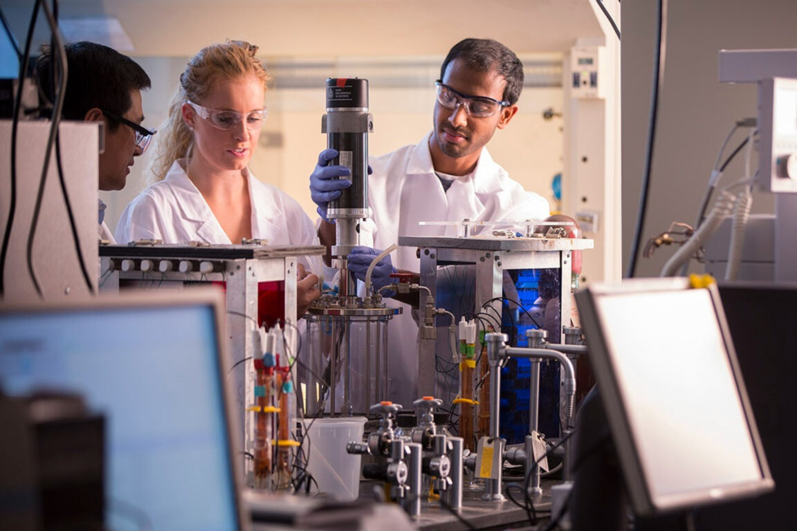 Picture of two chemical and biological engineering students conducting research and working in the lab.