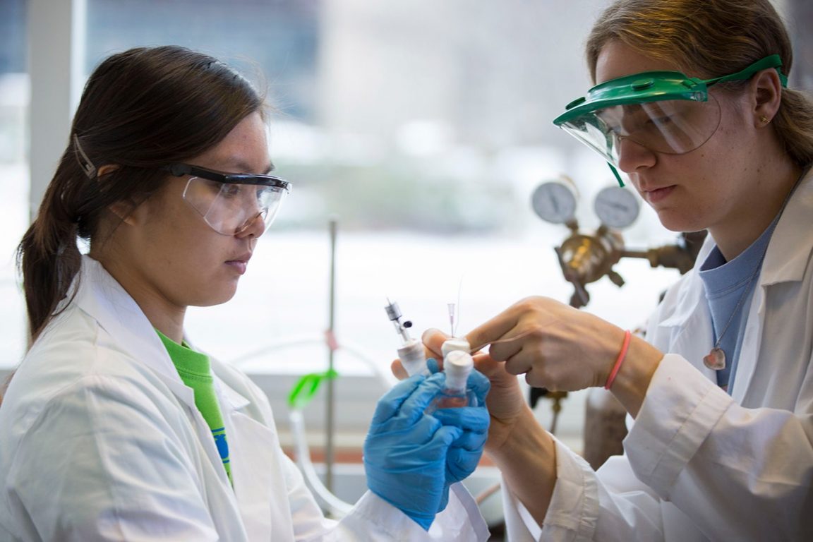 A photo of two chemical and biological engineering students conducting research and working in labs.