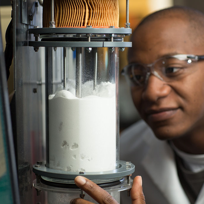 student watching processing of sample in lab setting